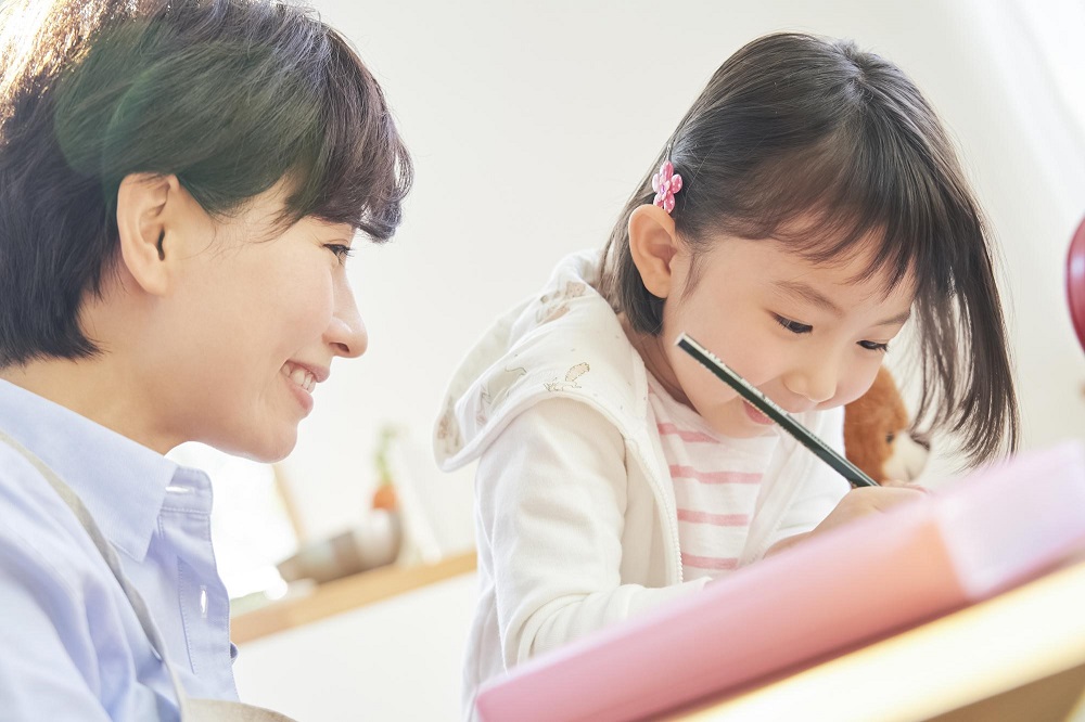 先生と一緒に勉強する女の子