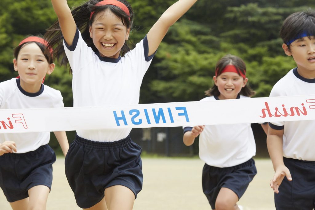 運動会でゴールテープを切る瞬間の子ども達