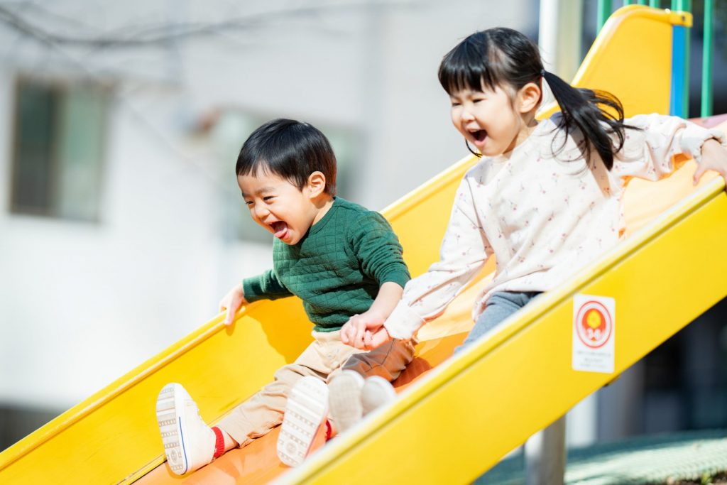 滑り台を滑っている男の子と女の子