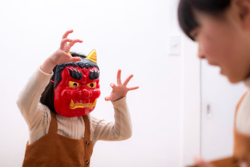 鬼のお面を持って楽しんでいる子供