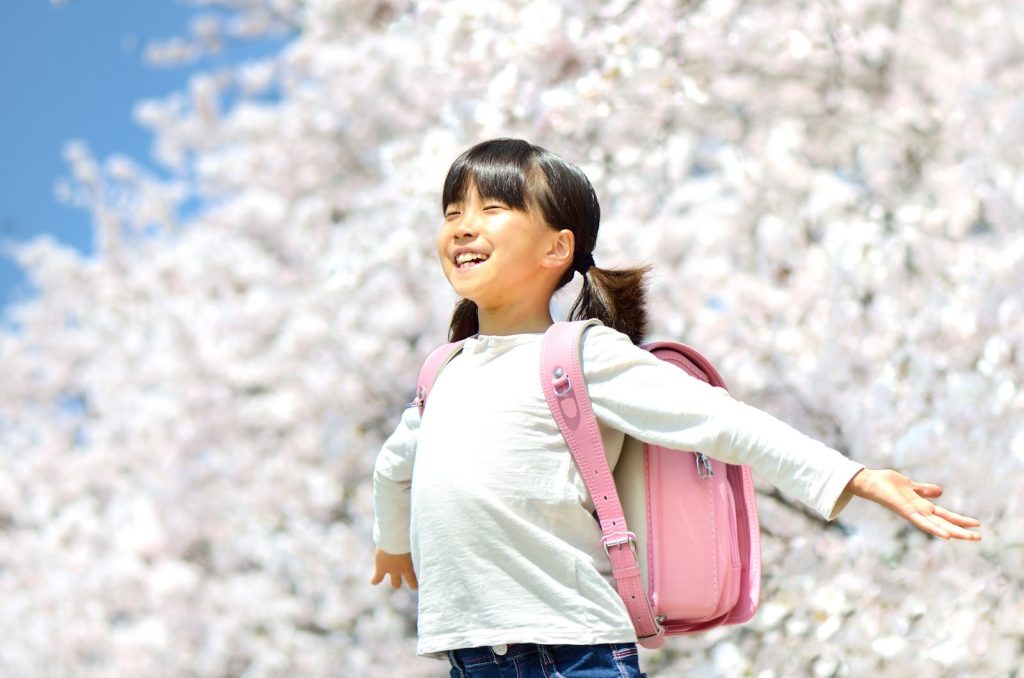 桜の前で深呼吸している女の子