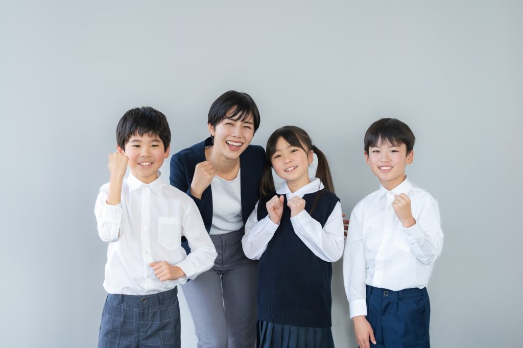 笑顔で写真をとっている子どもたちと先生