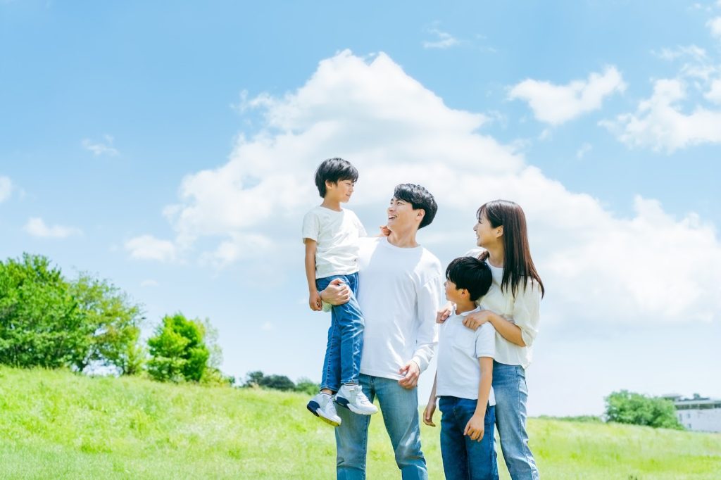 家族で青空の下笑っている様子