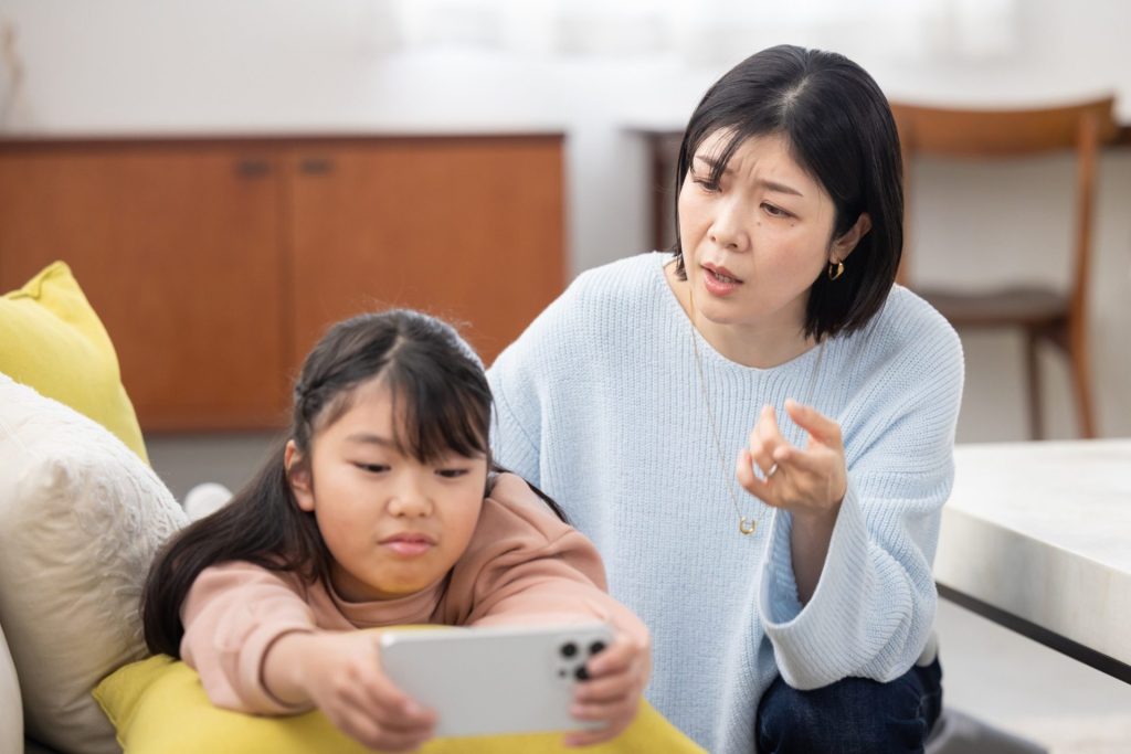 ゲームばかりしている子どもと注意しているママ