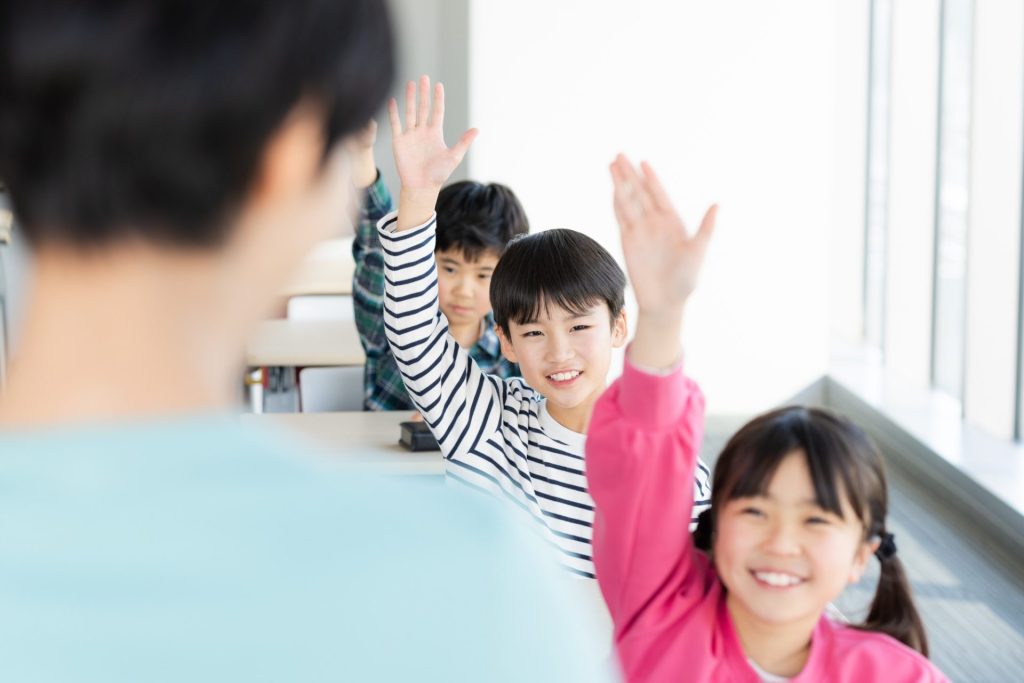 授業中手を上げている子どもたち