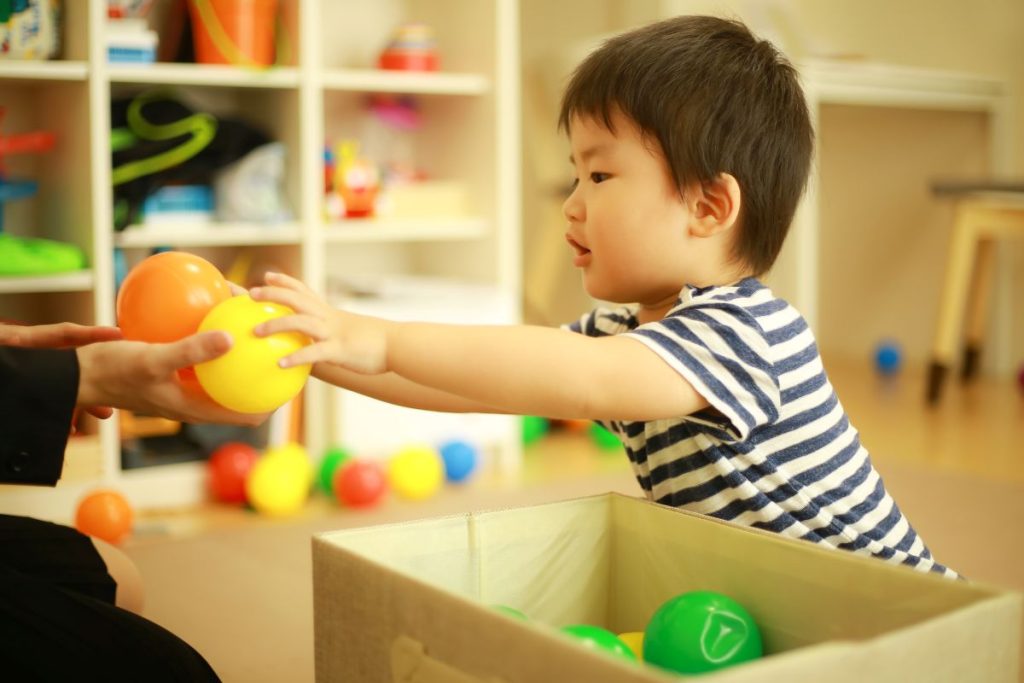 子どもがおもちゃのボールを片付けている画像