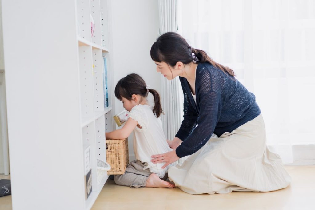 母親が子どもに寄り添って片付けをしている画像