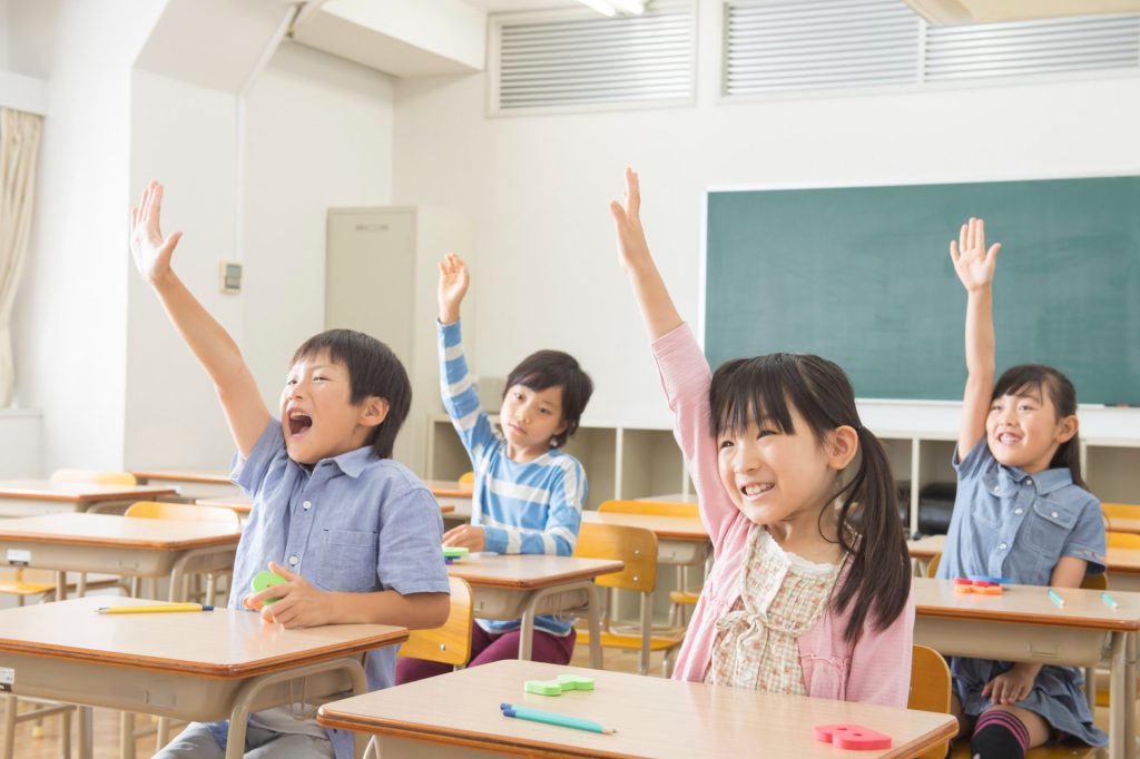 授業中0手を上げている小土手を挙げている子どもたち